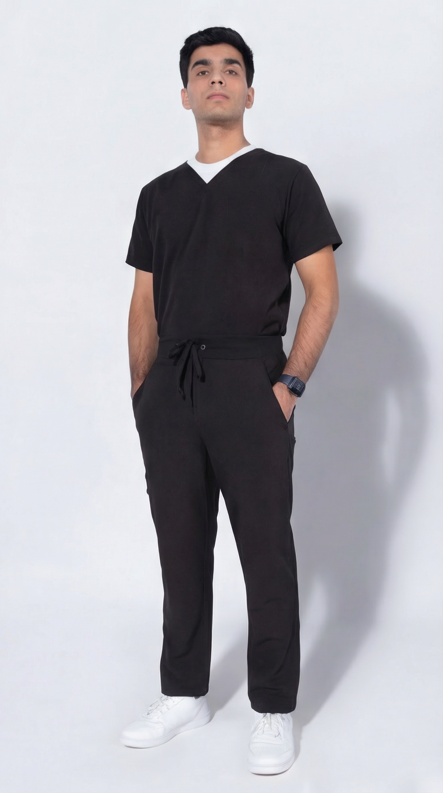 Man wearing a black outfit with white shoes on a white background