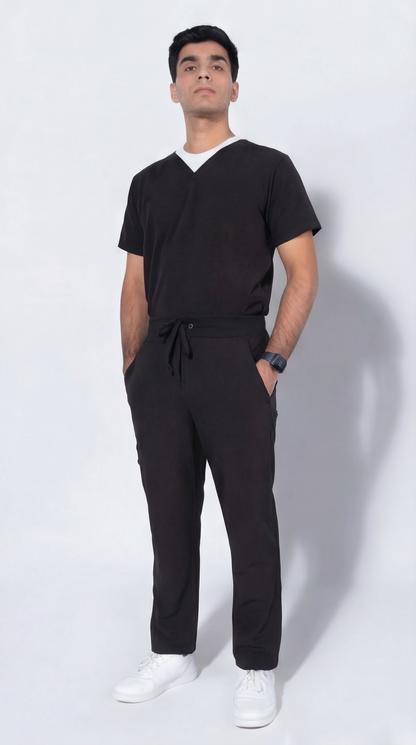 Man wearing a black outfit with white shoes on a white background